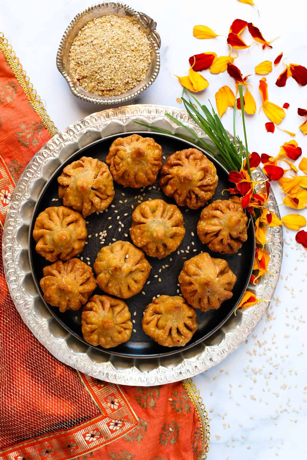 Fried Modak in a platter with sesame filling in a bowl 