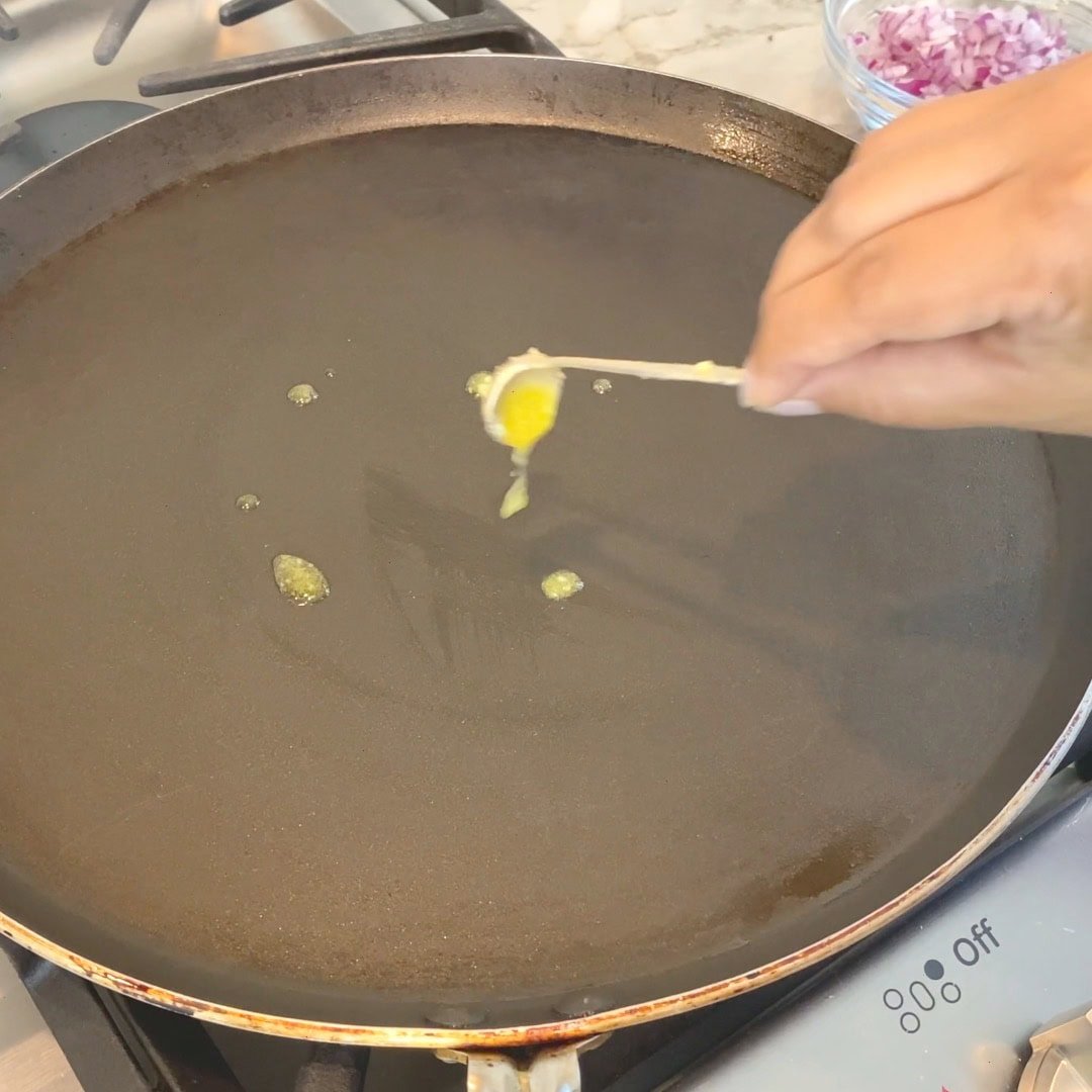 adding ghee to preheated pan 