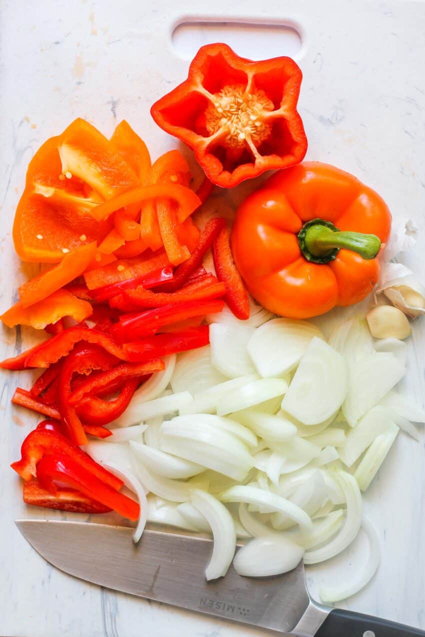 onions and peppers on a cutting board 