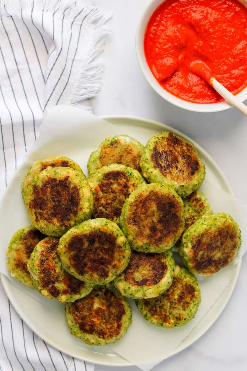 Broccoli tofu cutlets with red pepper chutney on white plate