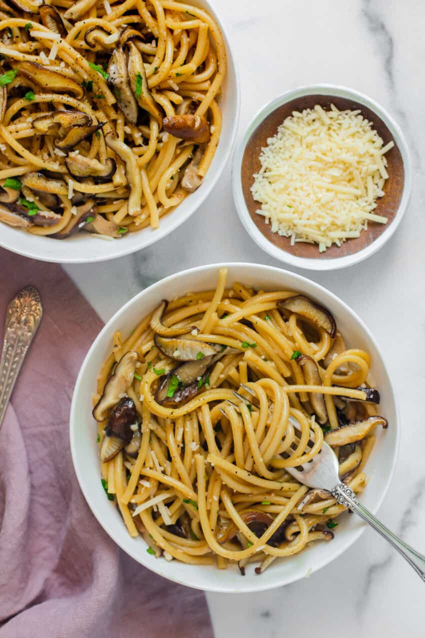 mushroom spaghetti in 2 white bowls