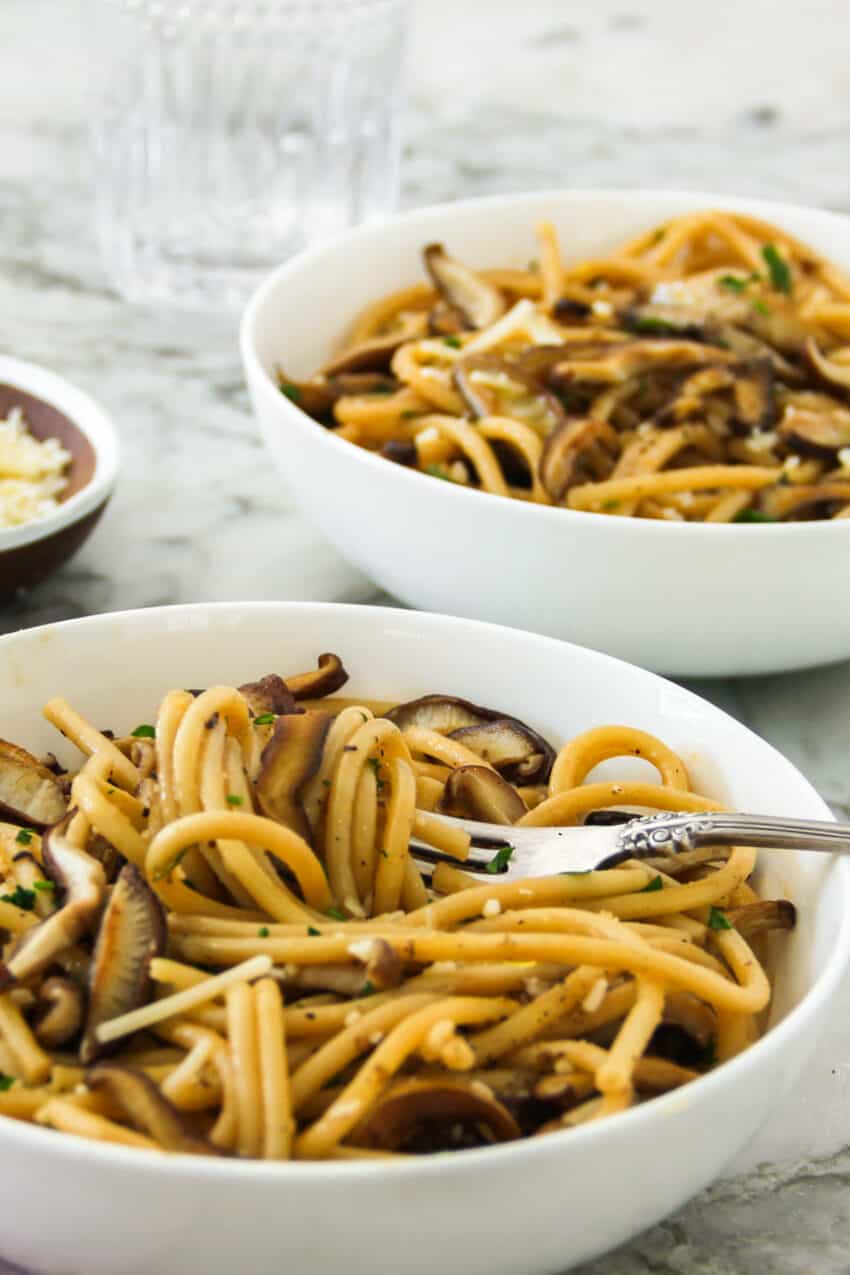 spaghetti with mushrooms in 2 white bowls 