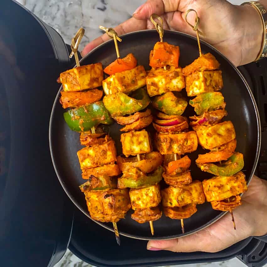 air fried paneer tikka skewers in a black plate 