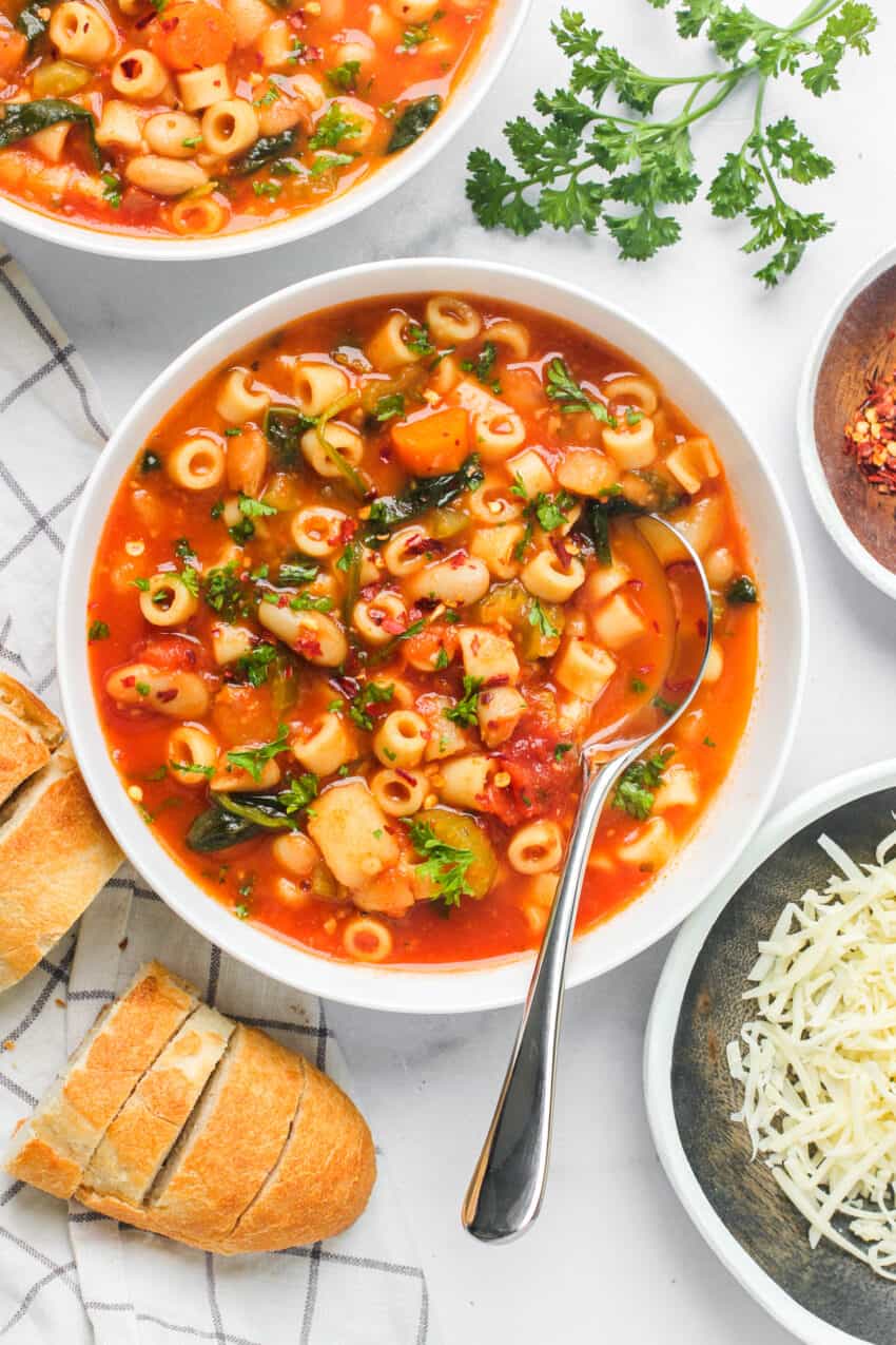 pasta e fagioli soup served in white bowls with baguette