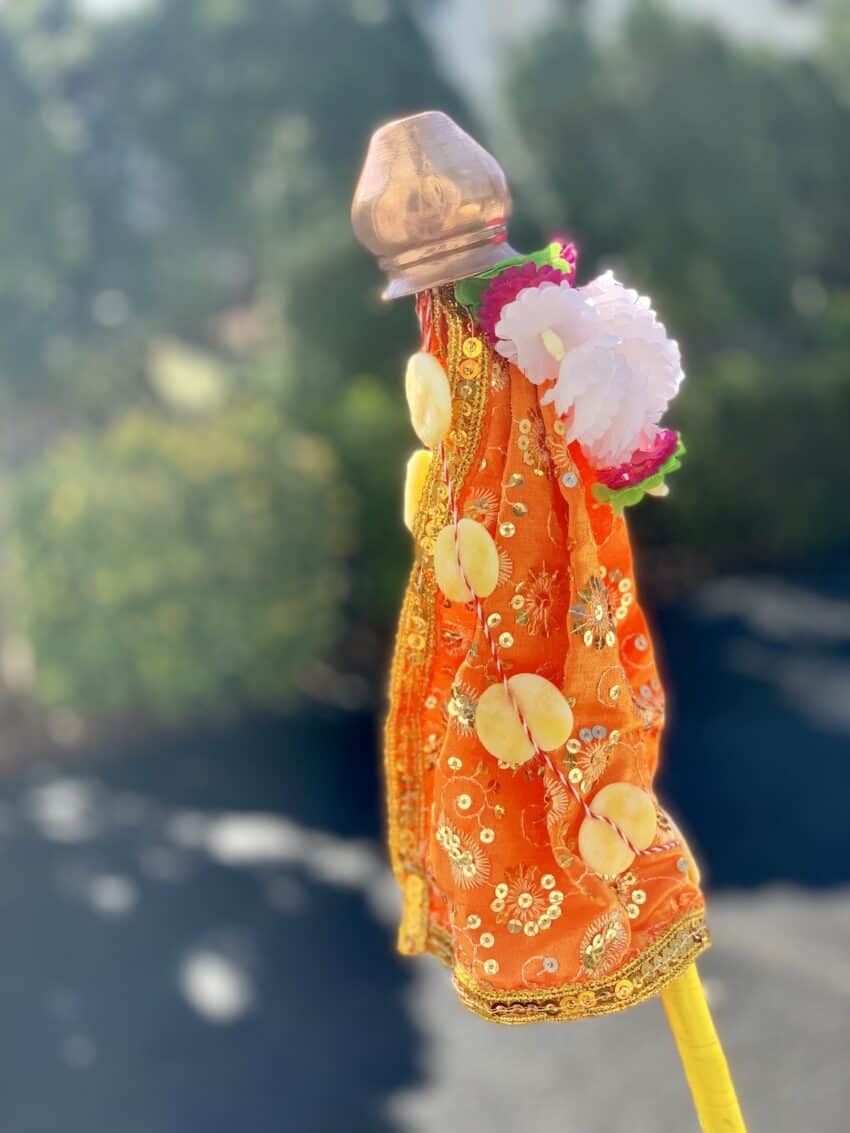 A beautiful display of Gudi with a bright silk cloth and flower garland