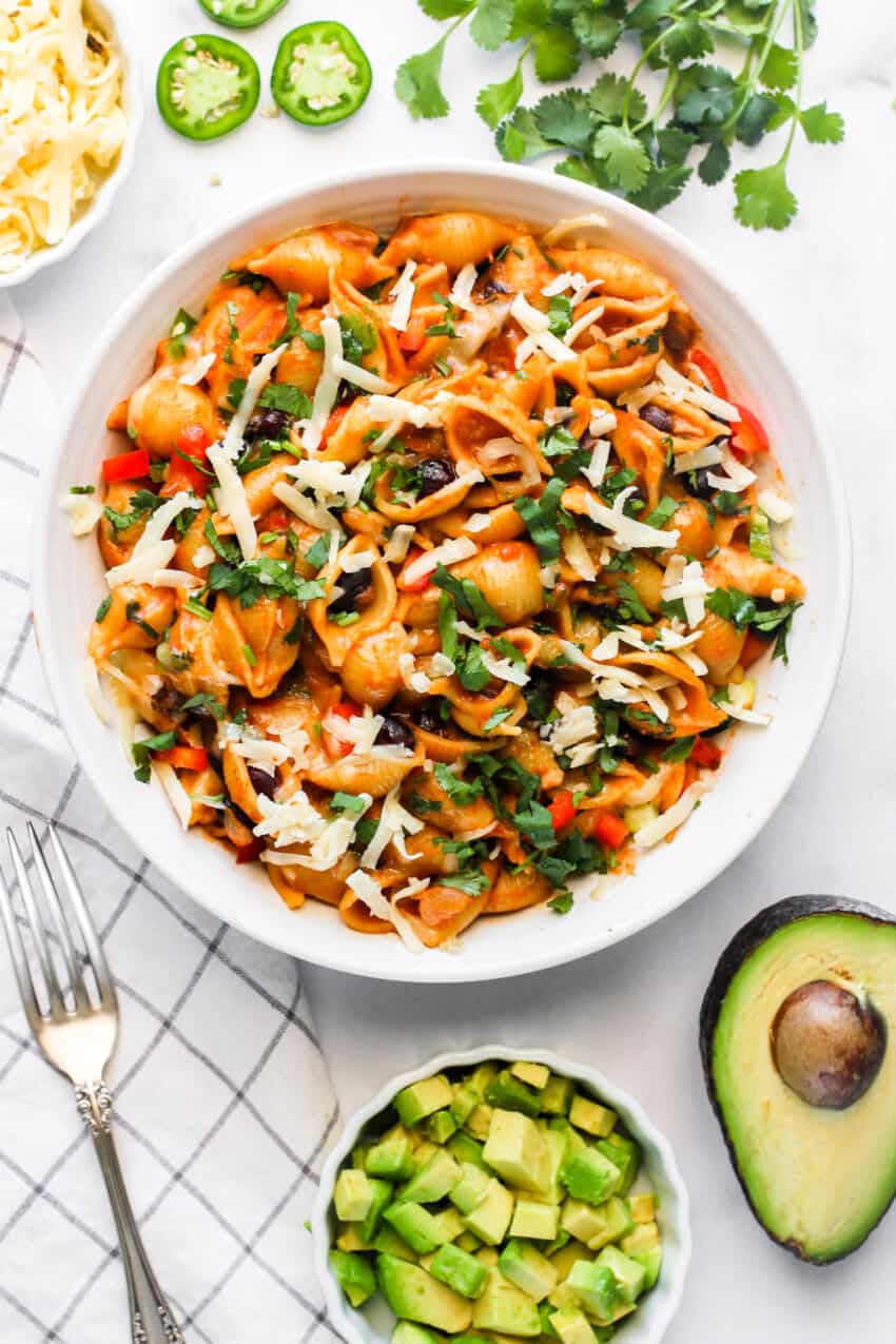 Taco pasta served in a white bowl topped with cilantro and cheese