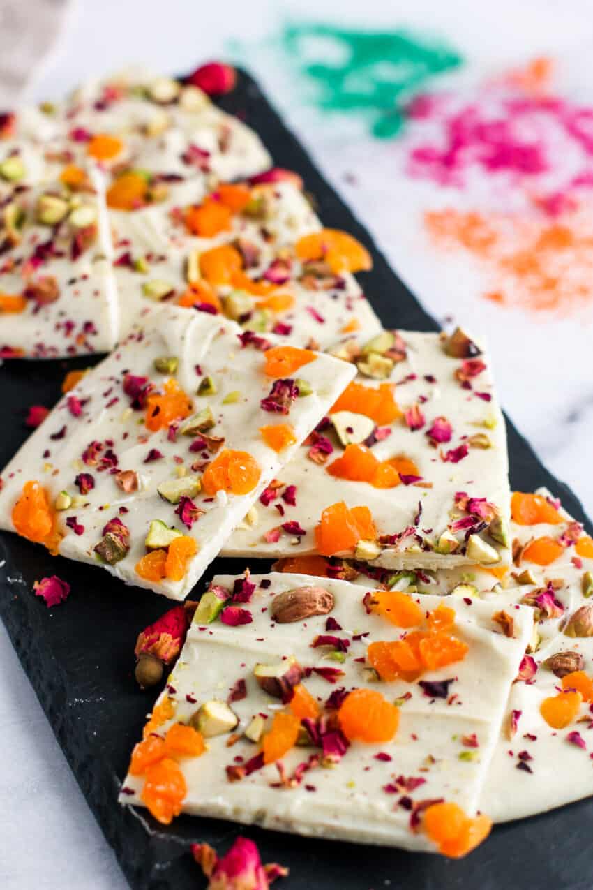 chocolate bark with pistachios, apricots and rose petals on a black platter 
