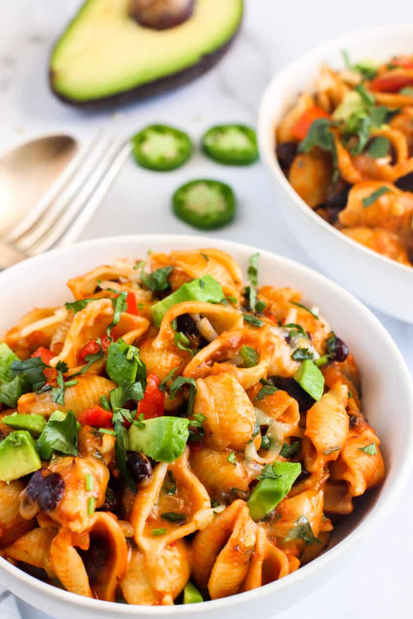Taco Pasta in white bowl topped with cilantro and avocado 