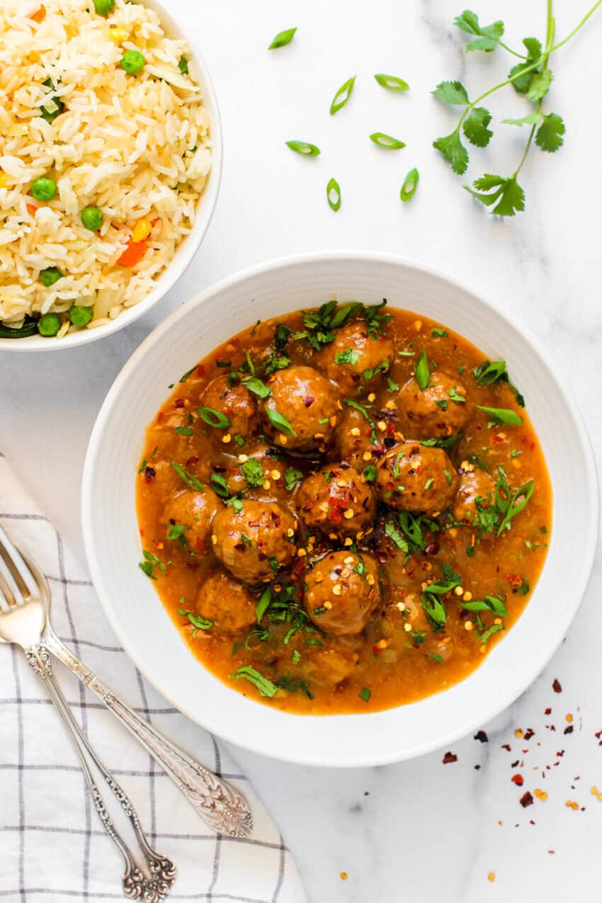 manchurian garnished with scallions in a white bowl 