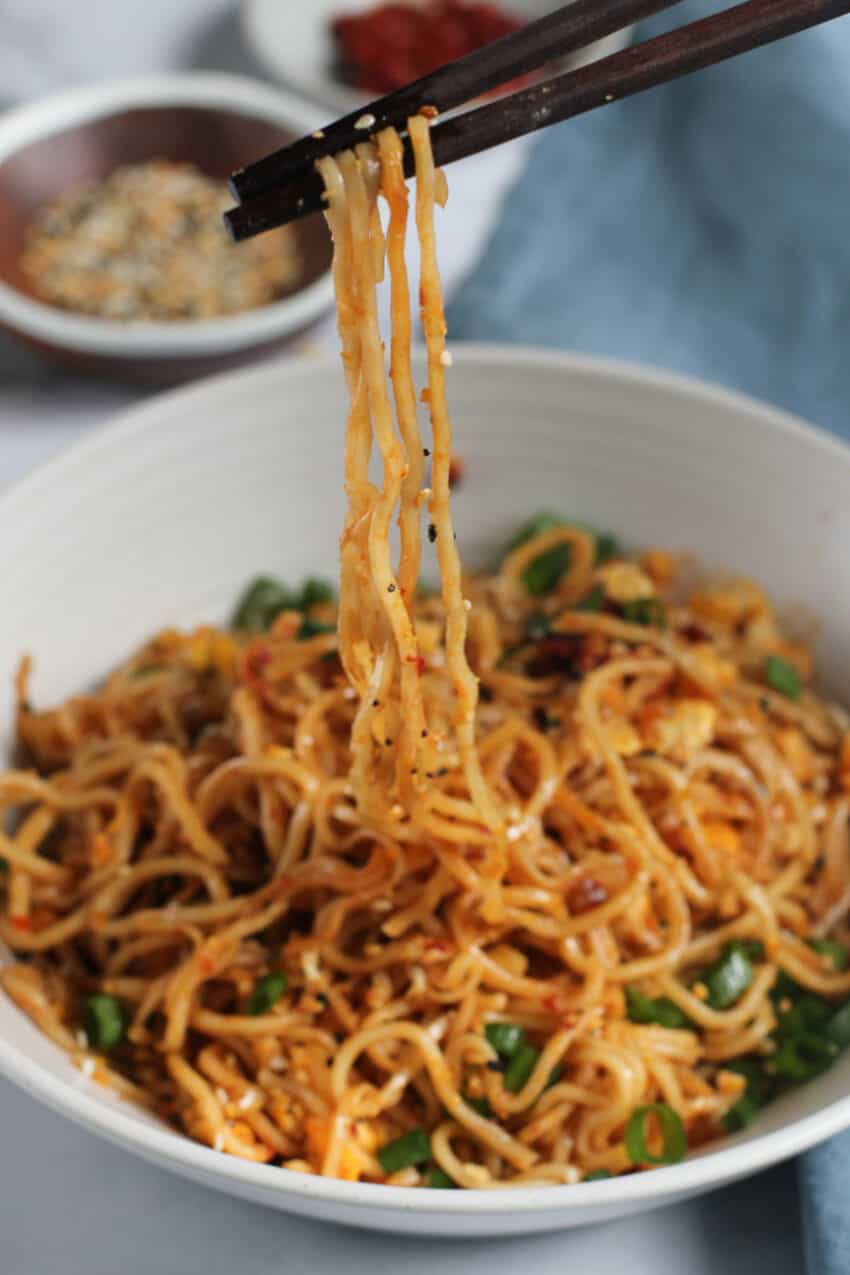Chop sticks picking up noodles from a bowl 