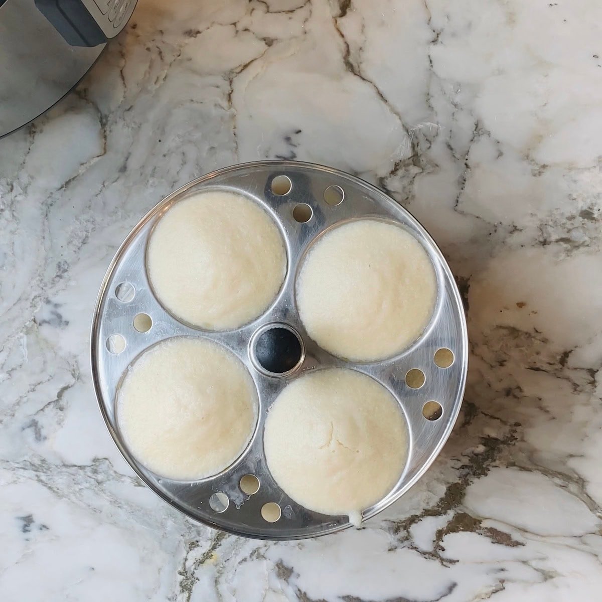 Idli steaming rack taken out of the steamer pot 
