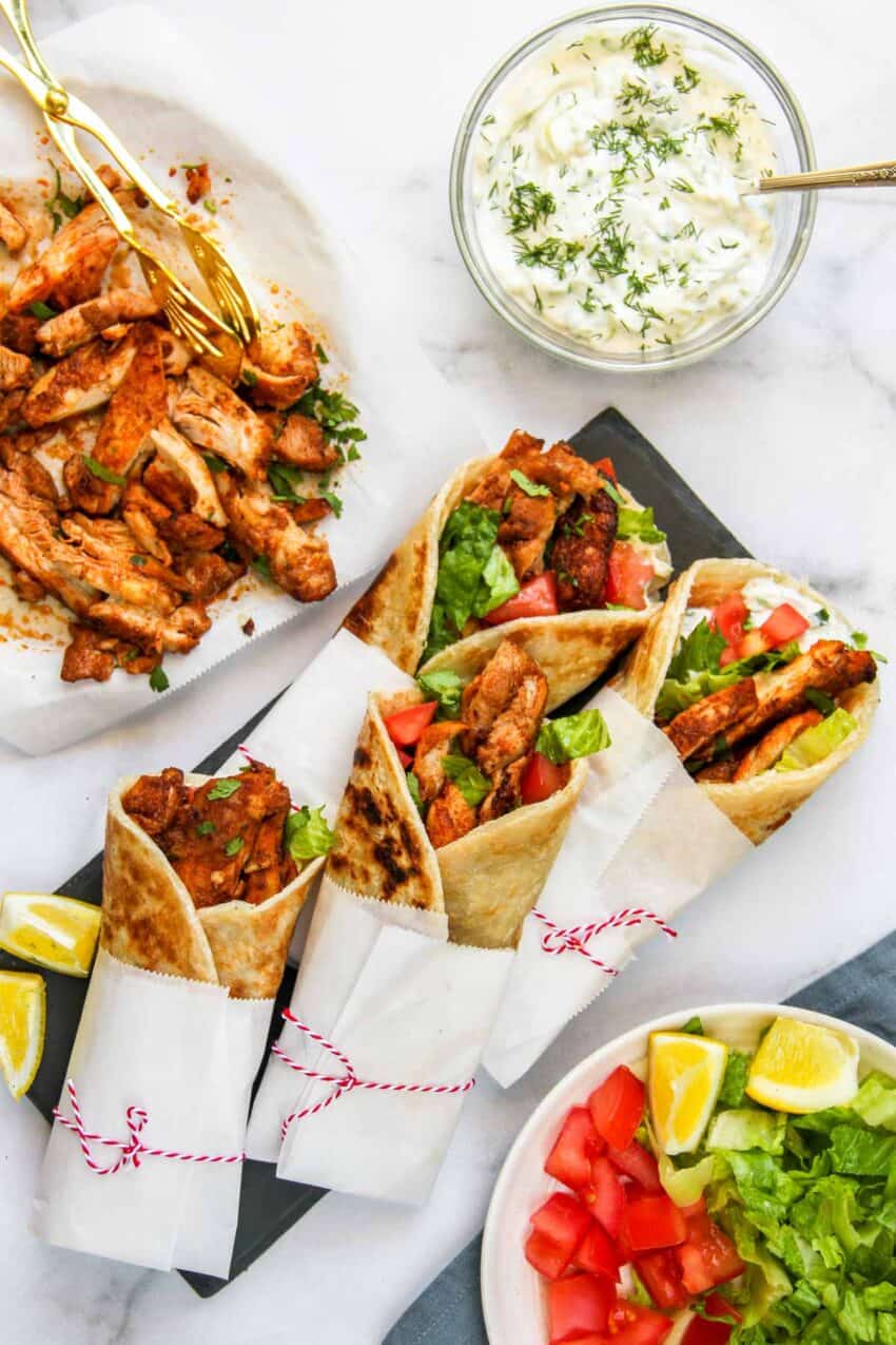 chicken served wrapped in parchment paper served along side grilled chicken and tzatziki