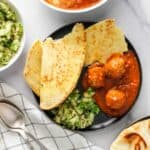 malai kofta served with naan and cucumber salad