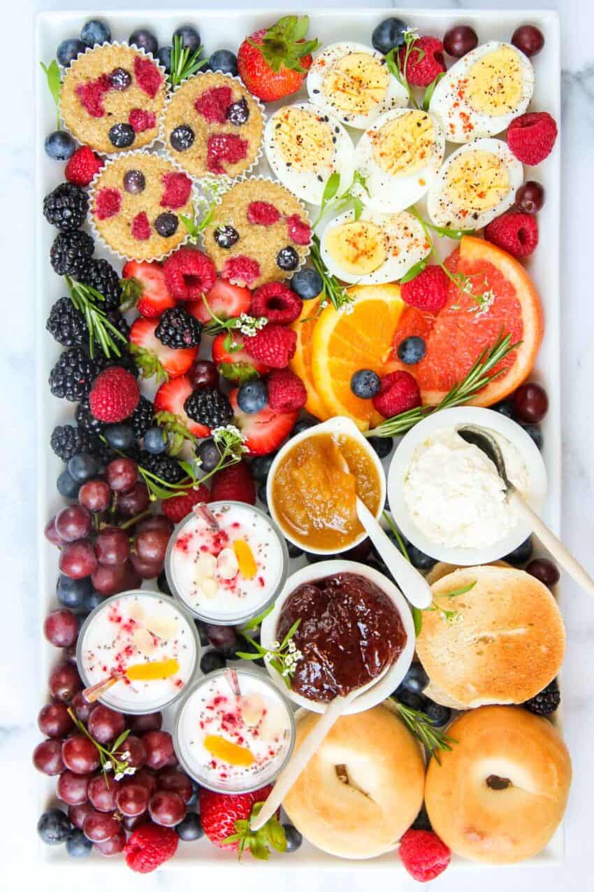 Breakfast Board with mini bagels, spreads, yogurt parfaits, mini muffins, eggs and fruits