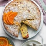 rhubarb almond cake with powdered sugar and candied orange slices