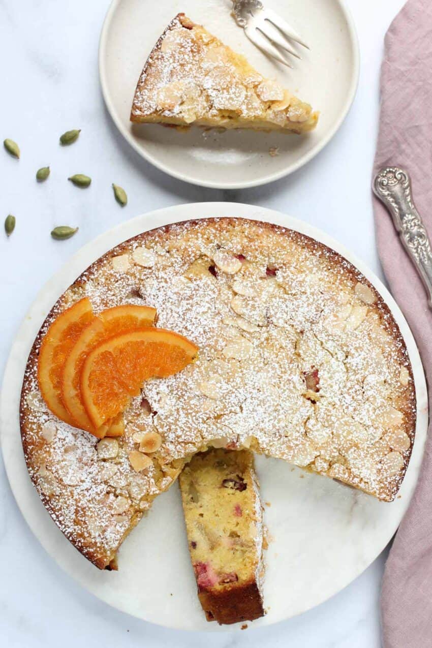 rhubarb almond cake with powdered sugar and candied orange slices 