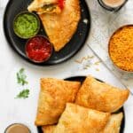 JAlapeno cheese samosas in 2 plates served with ketchup, chutney and chai