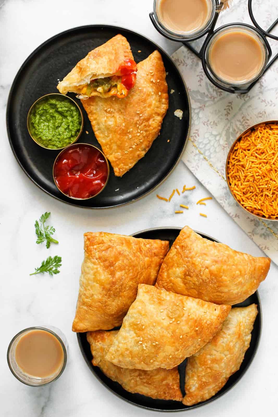 Jalapeno Cheese samosas in 2 plates served with chutney, ketchup and chai