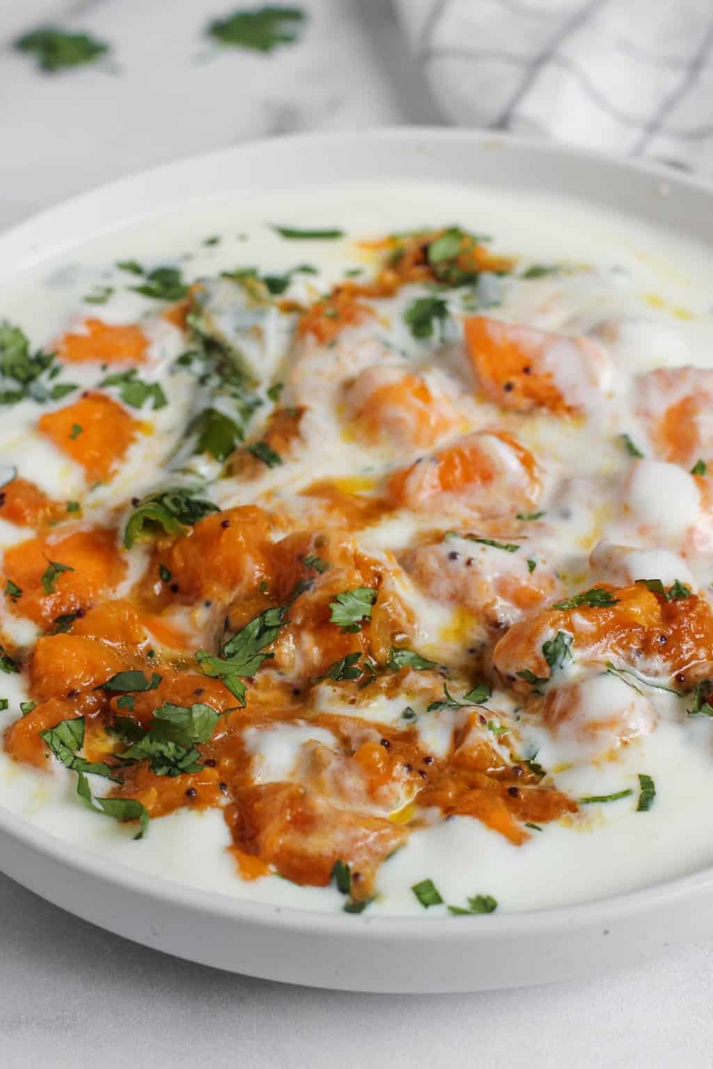 closeup photo of pumpkin raita in a white bowl 