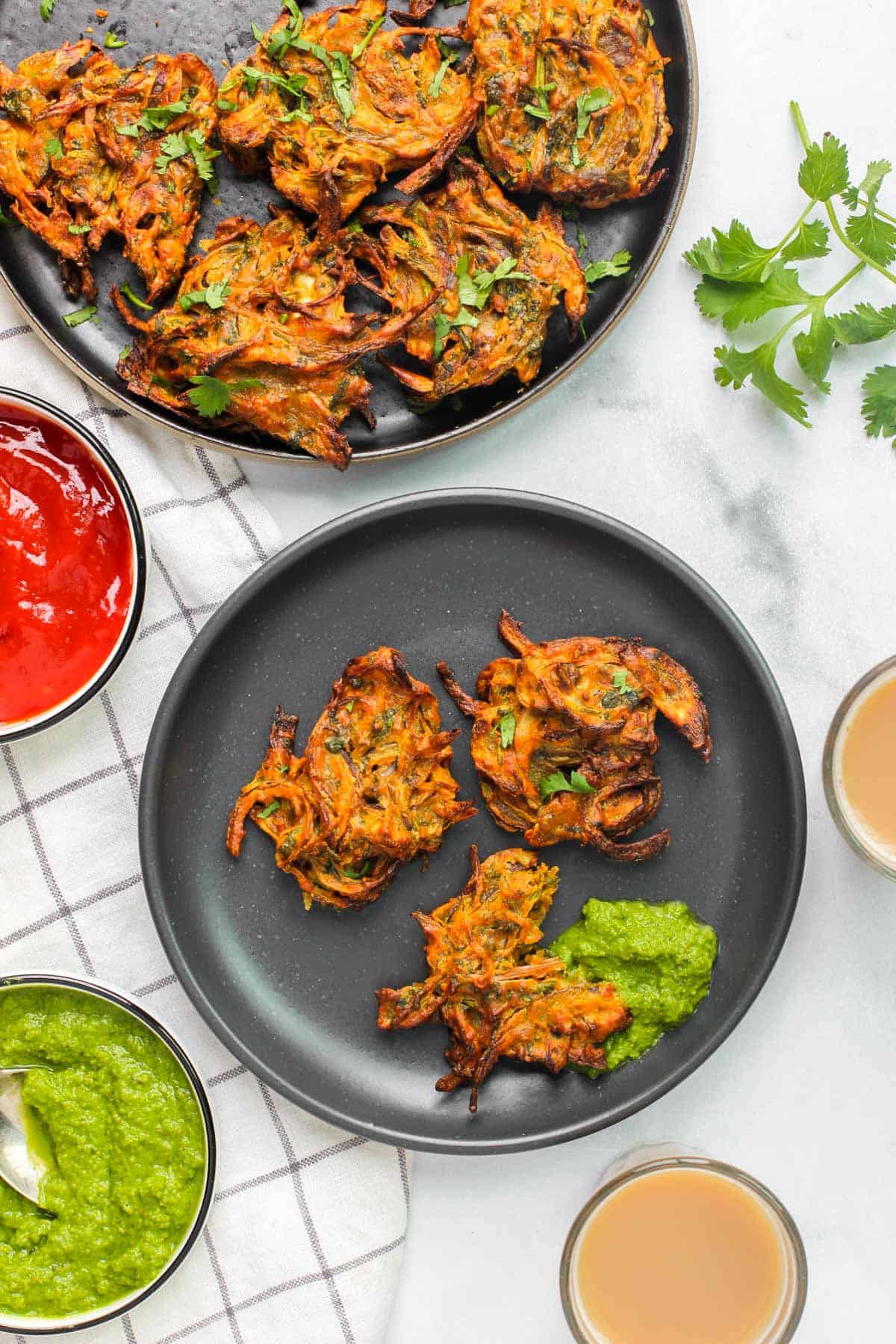 Onion pakodas served with ketchup, chutney and chai 