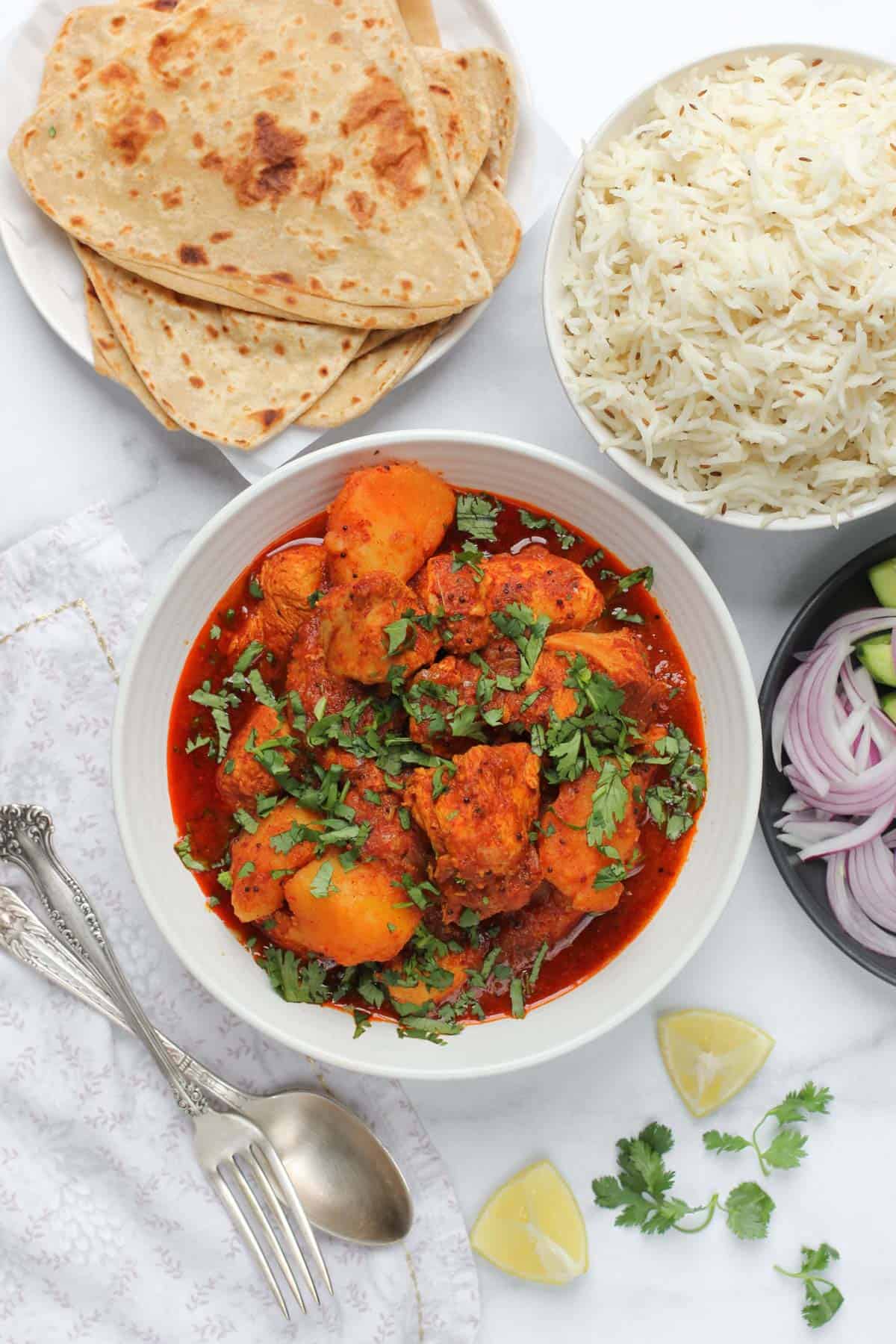 chicken vindaloo curry served with basmati rice and homemade parathas 