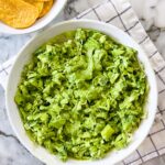 green goddess salad served in a white bowl with tortilla chips