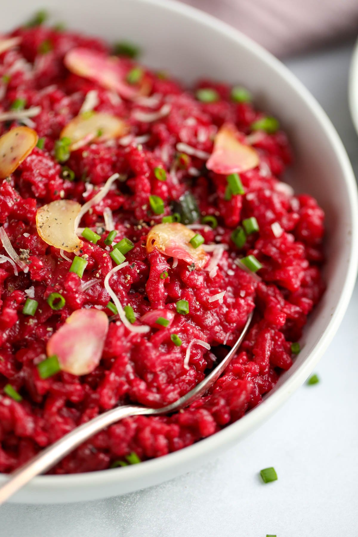 beet risotto served in a white bowl 