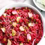 Beet risotto served in a white bowl