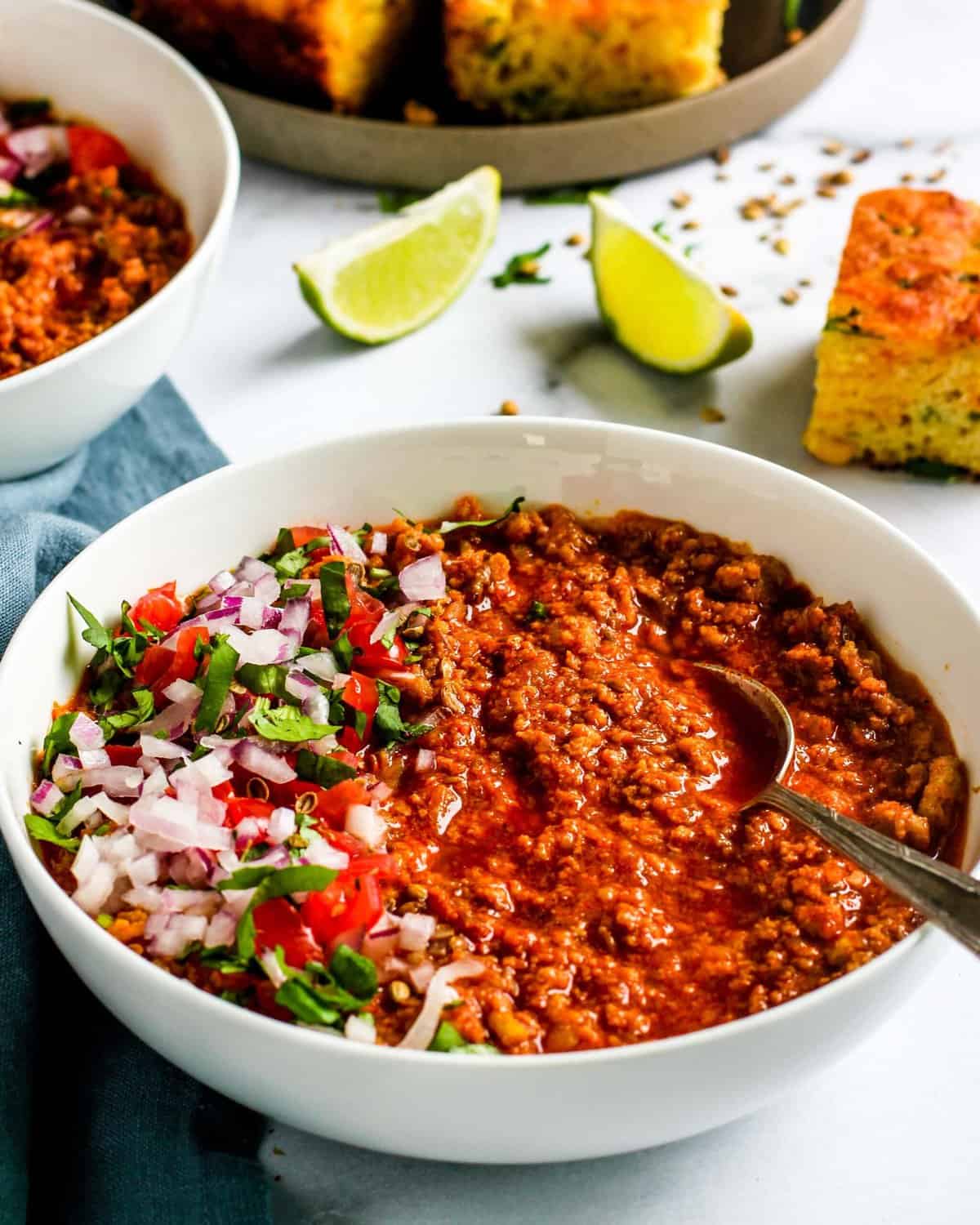 Spicy Chicken chili served in a white bowl alongside cornbread