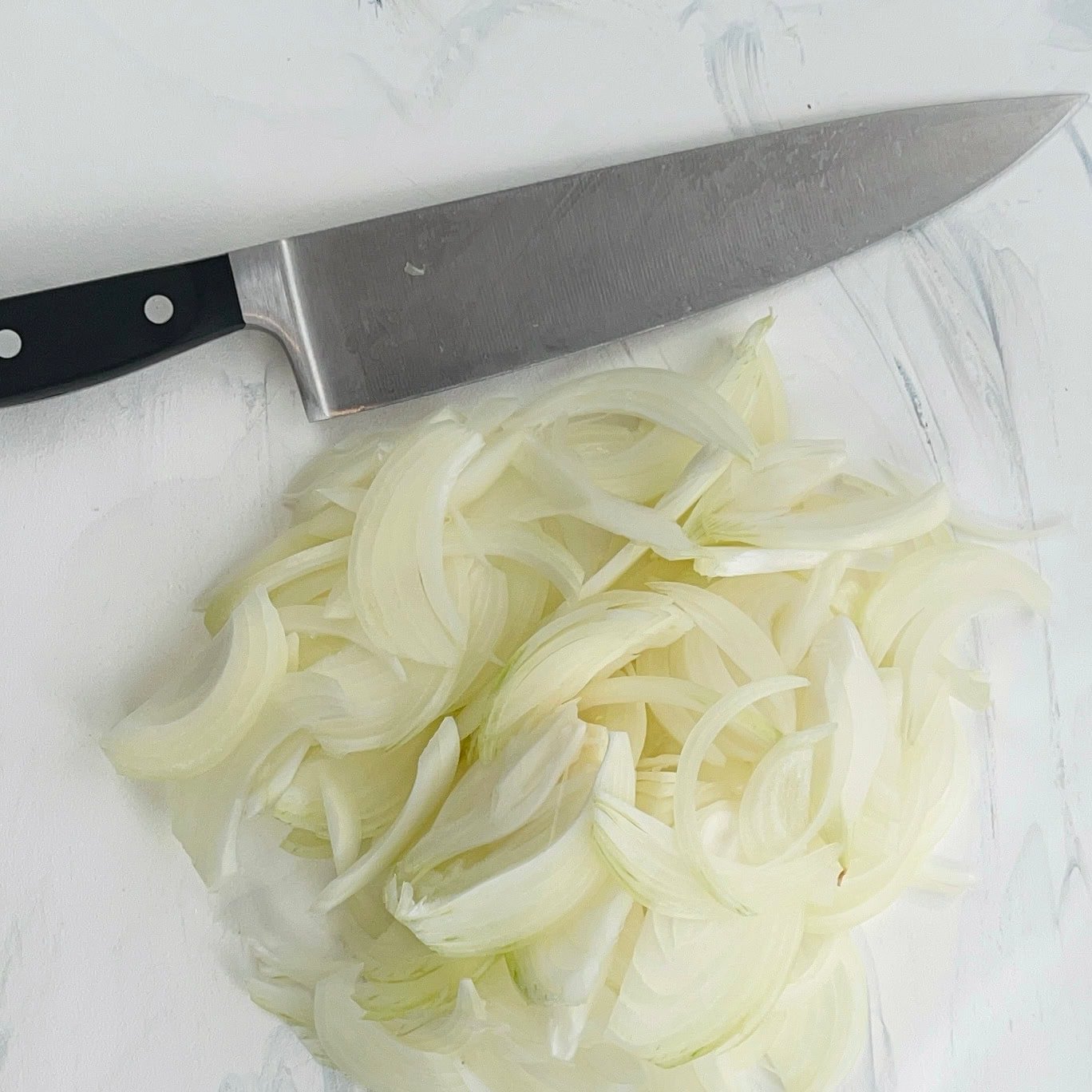 thinly sliced onion on a cutting board.