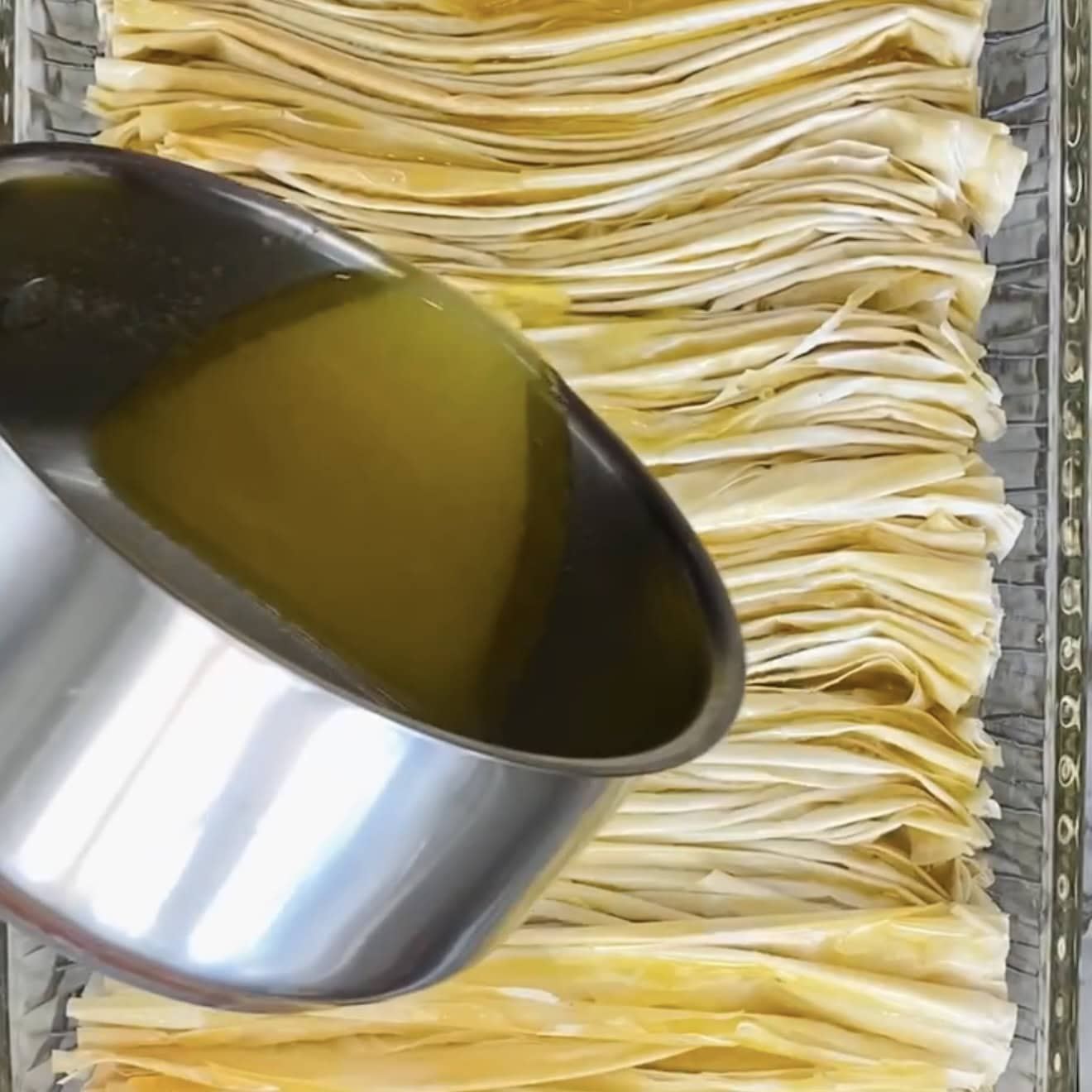 pouring melted butter over phyllo
