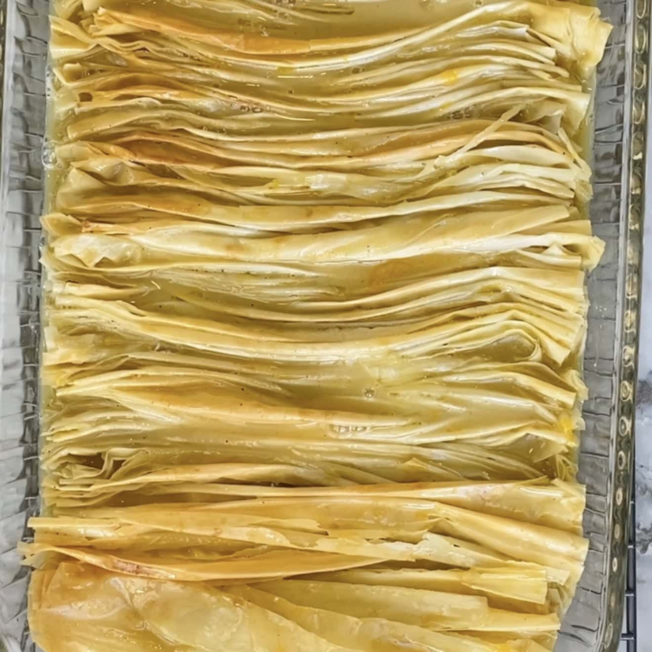 phyllo cake ready to be baked again after adding the custard