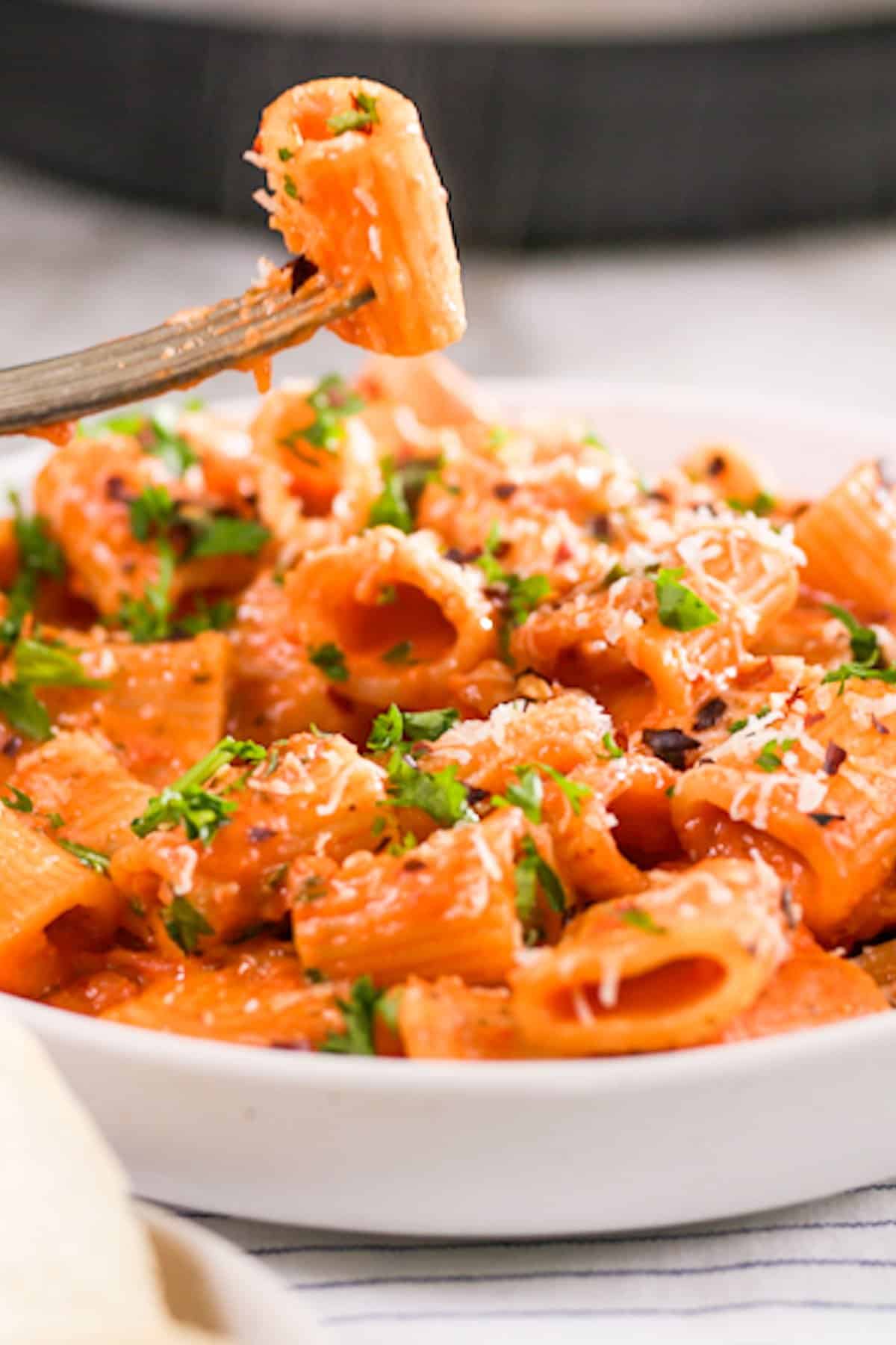 Pasta with creamy vodka sauce garnished with parsley, parmesan and red chili flakes