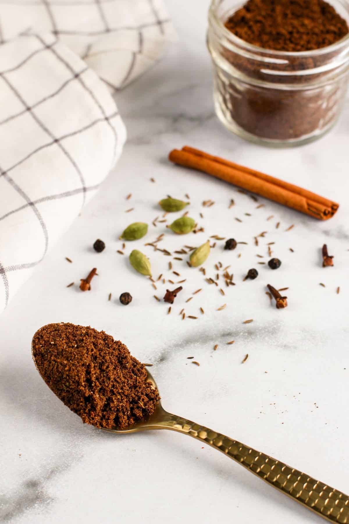 garam masala in a glass jar and in a spoon