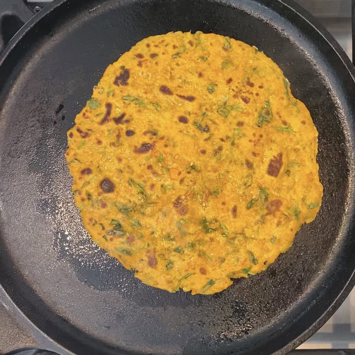 cooked methi thepla on a pan. 