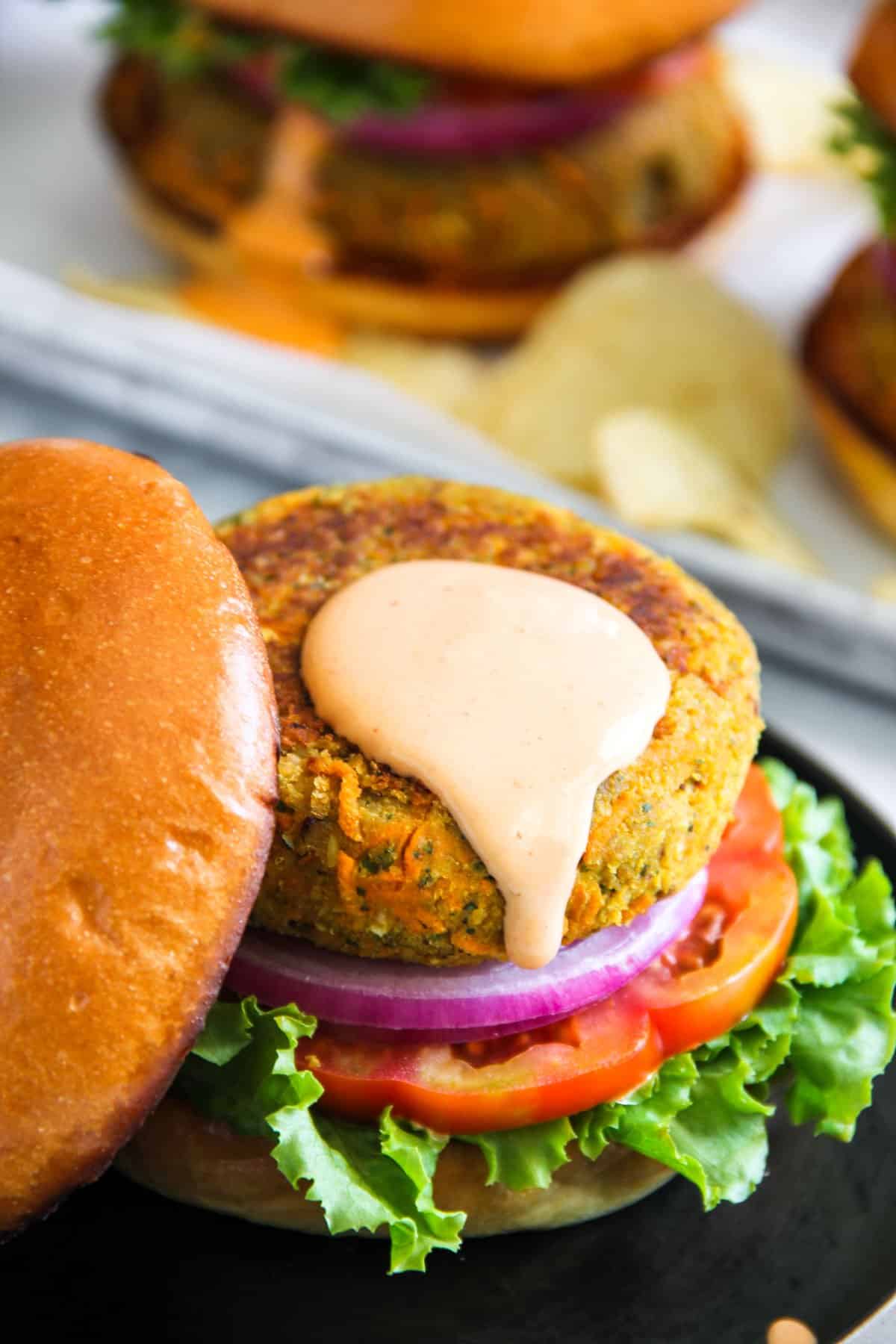 Masala chickpea burger served on a brioche bun d with onion, tomato and lettuce and spicy mayo 