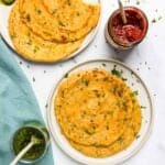 Masoor Dal chilla served in two white plateswith pickles and chutney