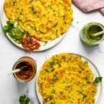 Mung Dal Chilla served in two white plates with pickle and chutney