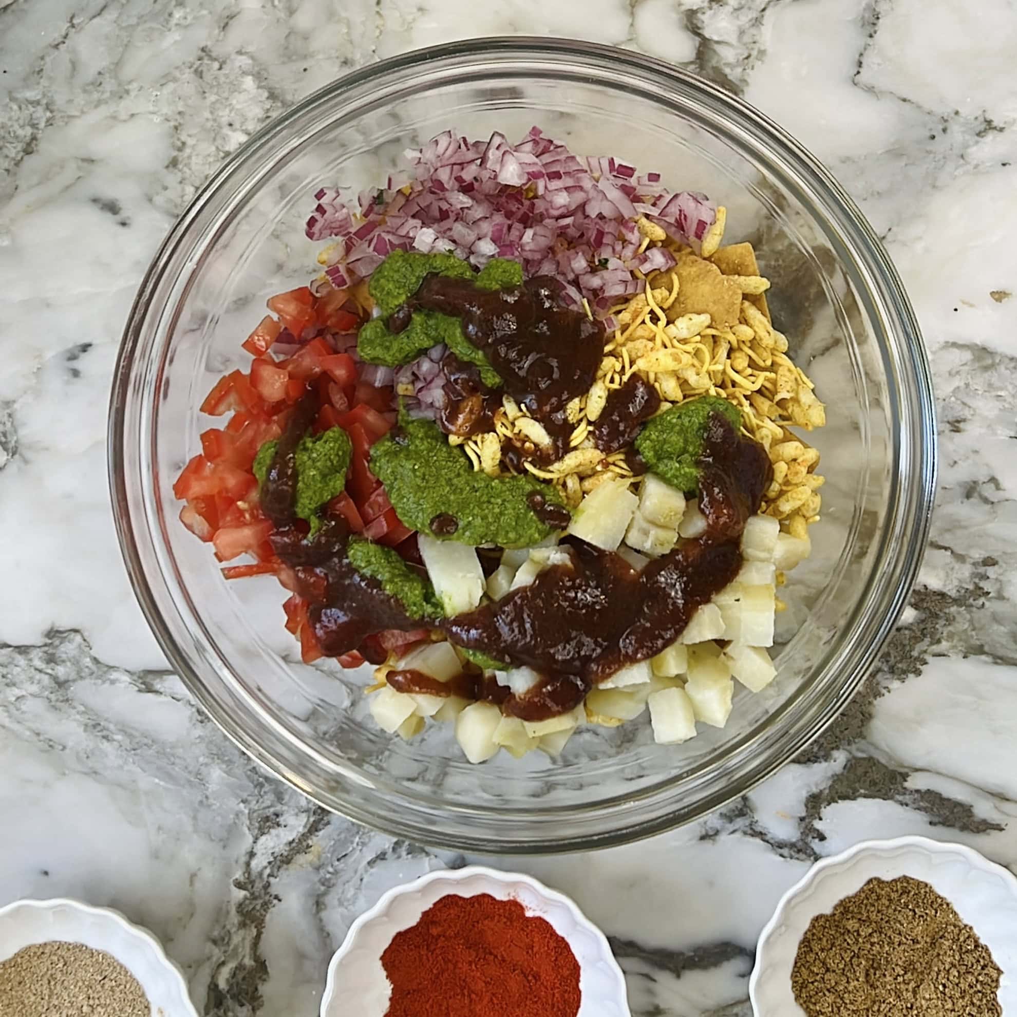 chutneys drizzled over bhel.