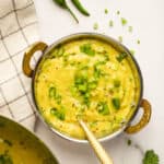 pithla garnished with cilantro and scallions
