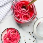 pickled onions in a glass jar and small dish