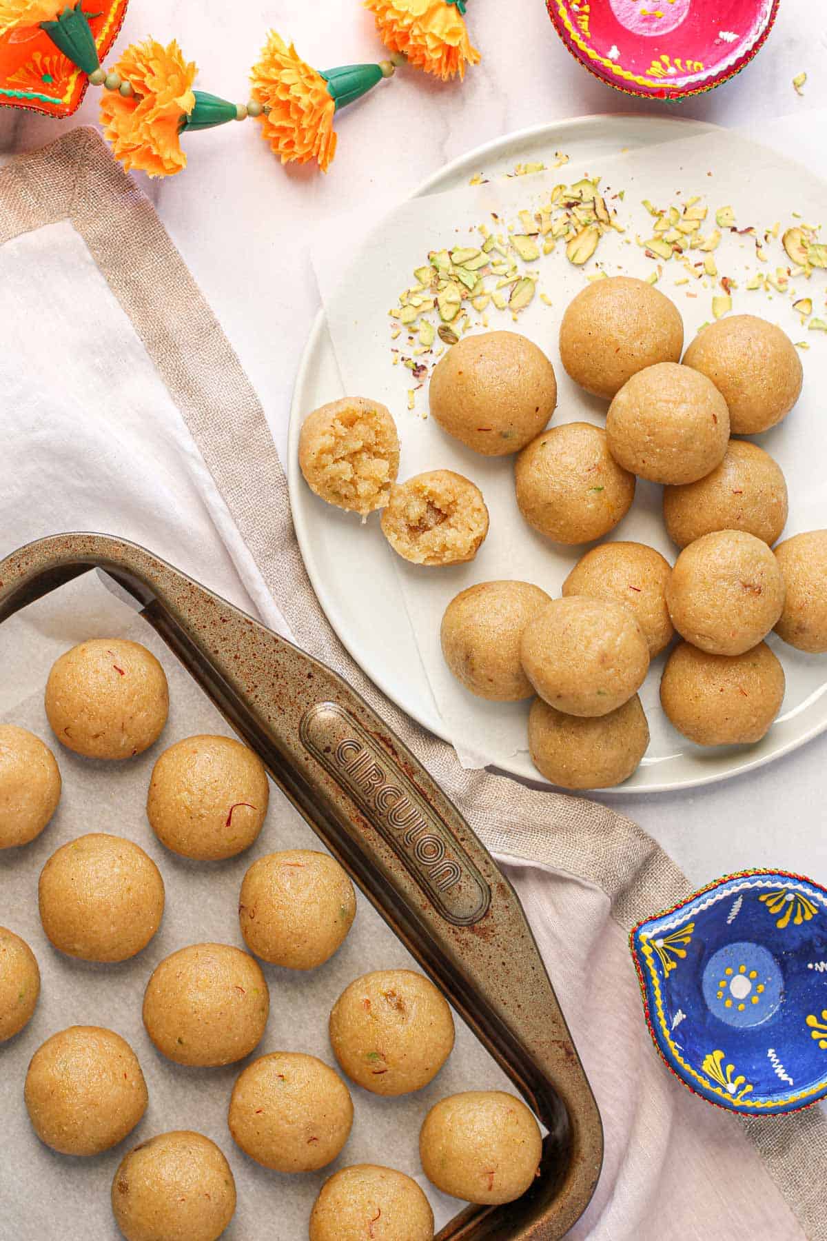 rava laddu in a white plate with sliced pistachios on the side 