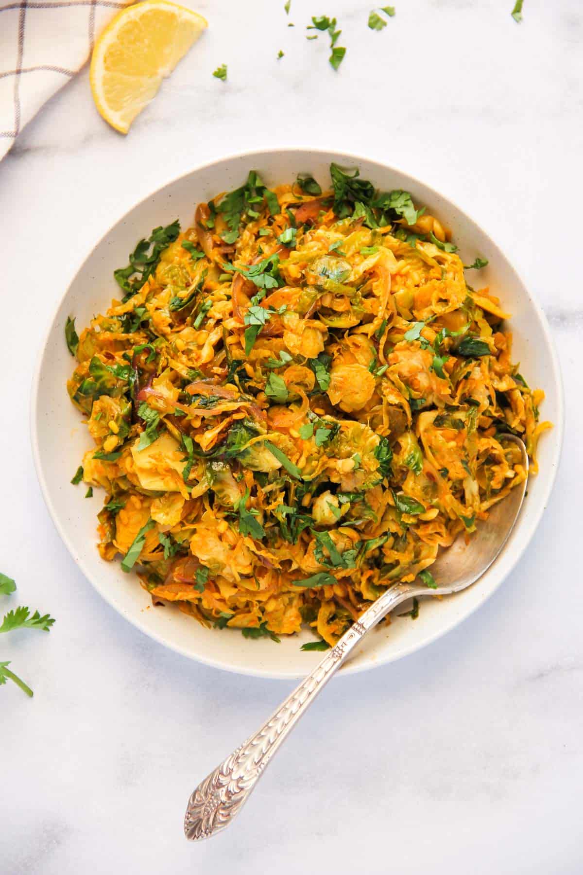 brussels sprouts sabzi in a white bowl  garnished with cilantro 