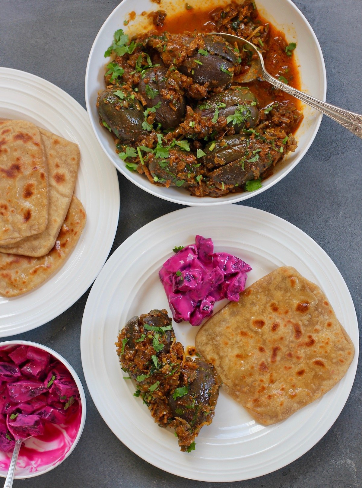 baingan masala served with parathas and beet raita 