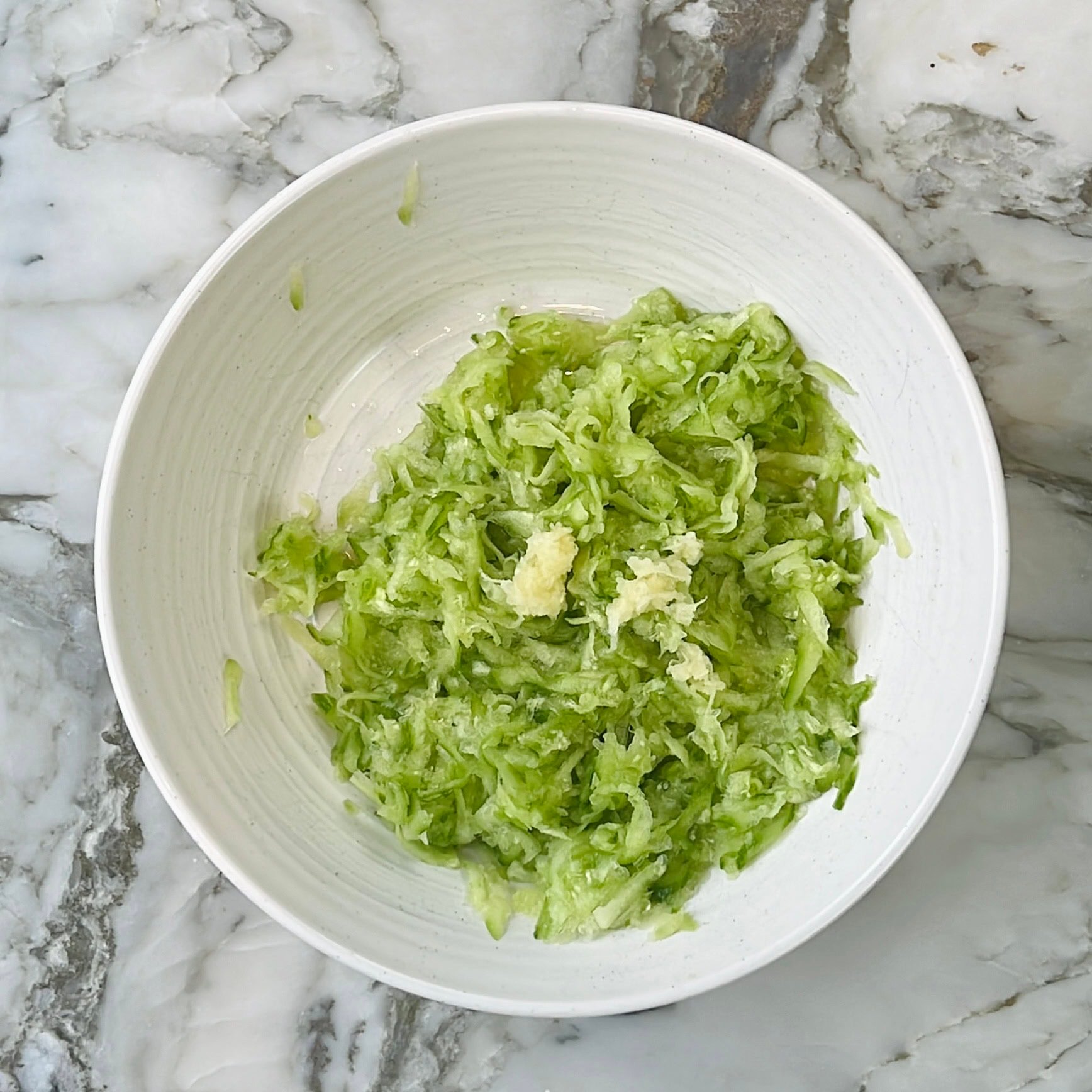 grated cucumbers and garlic in a bowl