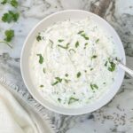 cucumber raita in a white bowl