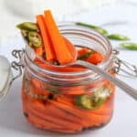 pickled carrots with green chilies in a glass jar