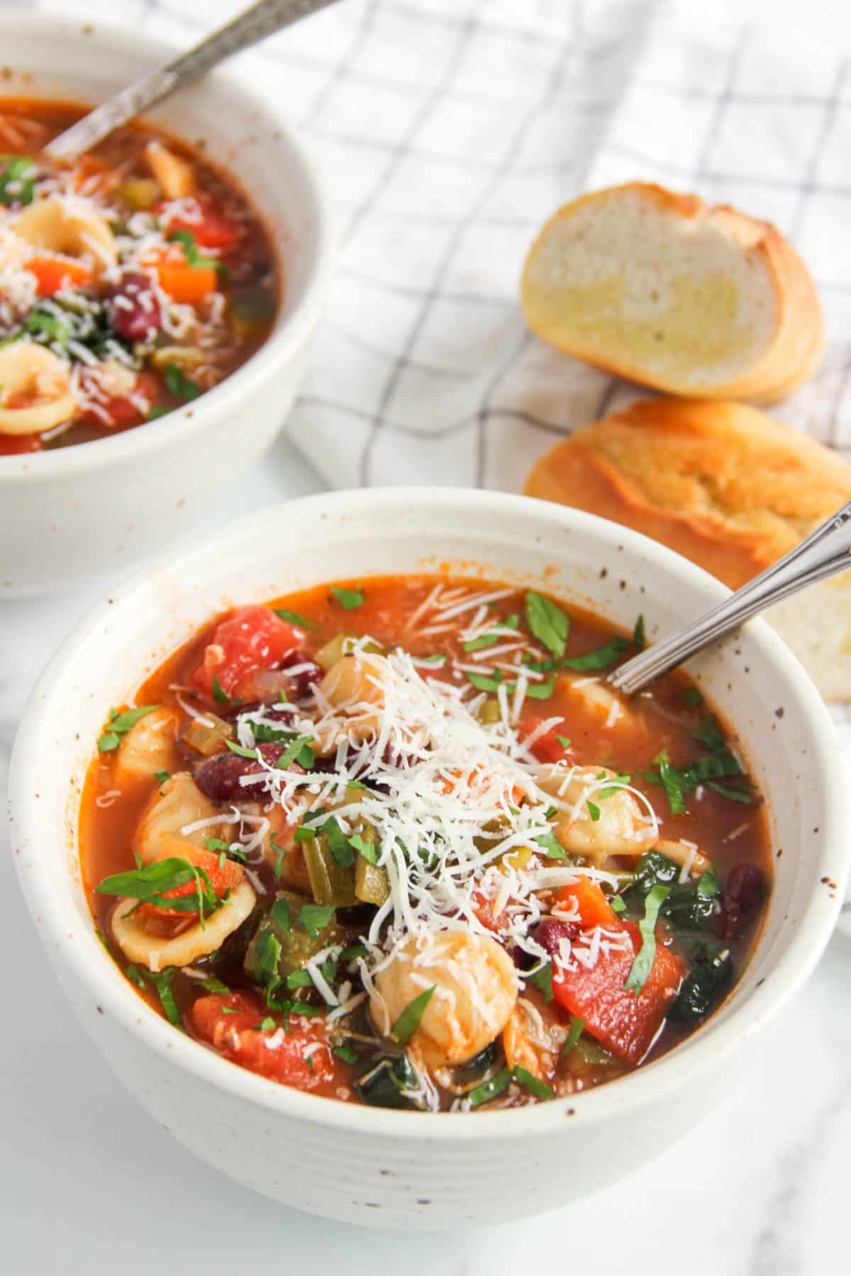 minestrone soup in a bowl with parmesan cheese on top 