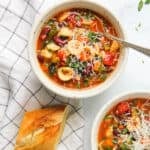 minestrone soup served in two white bowls