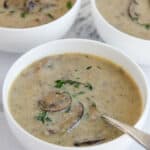 mushroom soup served in bowls and garnished with fresh thyme